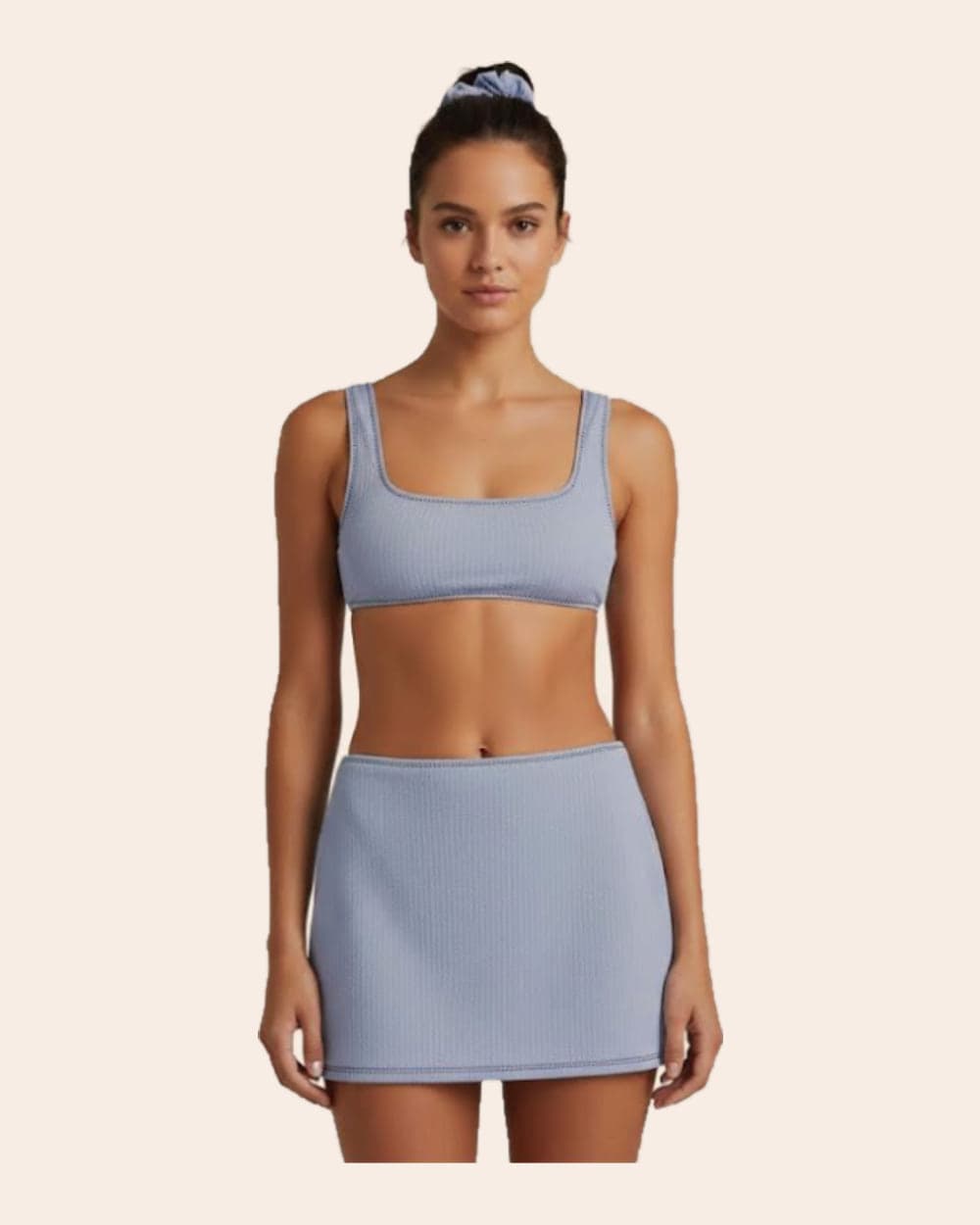 A model in a powder blue ribbed square-neck top and matching mini skirt, hair tied up in a scrunchie