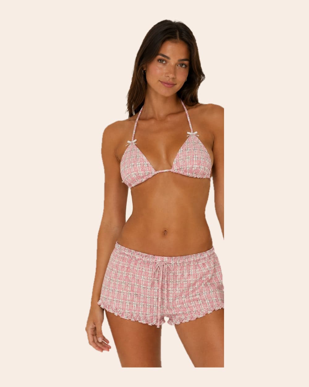 A model in a pink tweed triangle top and matching ruffle-hem shorts